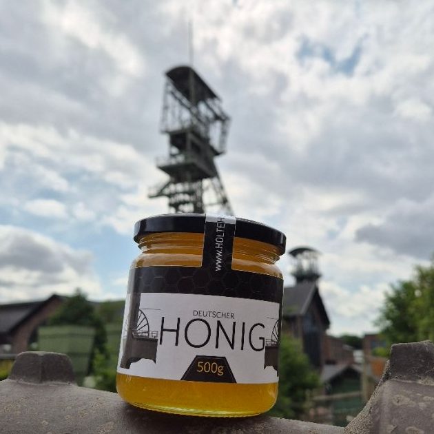 Wabenhonig Verpackte Wabenhonig mit Bienenstock-Motiv, umgeben von Kaffeebohnen.
